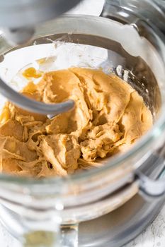 Mixing ingredients in a kitchen stand mixer to bake soft oatmeal raisin walnut cookies.