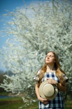 beautiful girl in a dress walking in the spring forest where the trees bloom