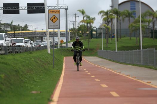 salvador, bahia, brazil - april 2, 2019: Person riding a bicycle on a bike path on Avenida Luiz Viana, along line 2 of the subway in the city of Salvador.