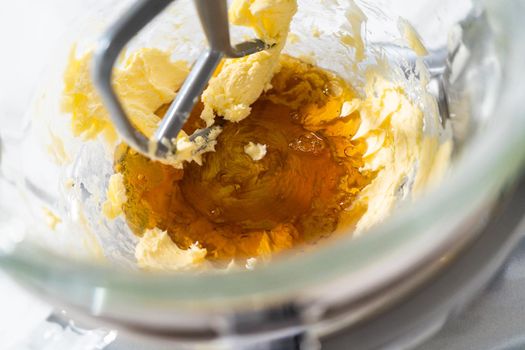 Mixing ingredients in a kitchen stand mixer to bake soft oatmeal raisin walnut cookies.