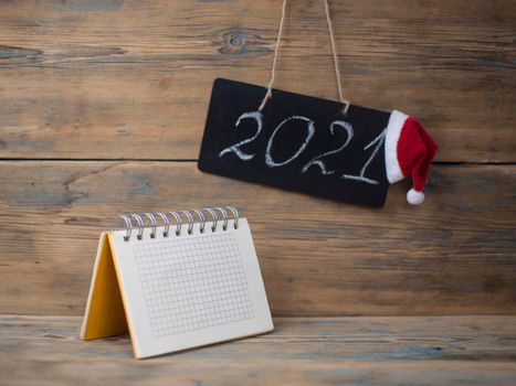 2021 - chalkboard with outlined text with red Santa hat - on wood