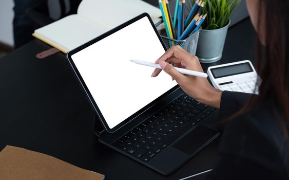 Cropped shot of a business woman sitting at modern office room and using blank screen digital tablet computer.