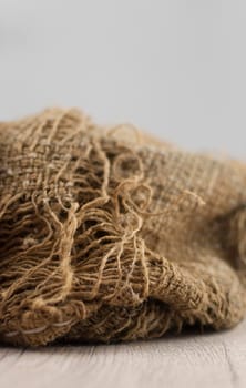 Wood table with old torn burlap tablecloth texture