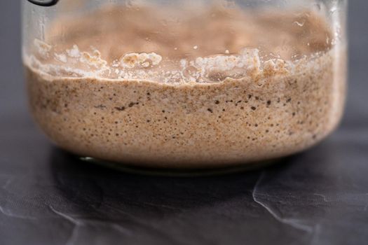 Homemade wheat sourdough starter in a glass mason jar.