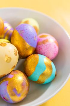 Colored and painted with gold hard-boiled eggs on a yellow background.