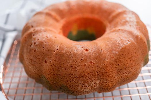 Cooling freshly baked bundt cake on a round cooling rack.