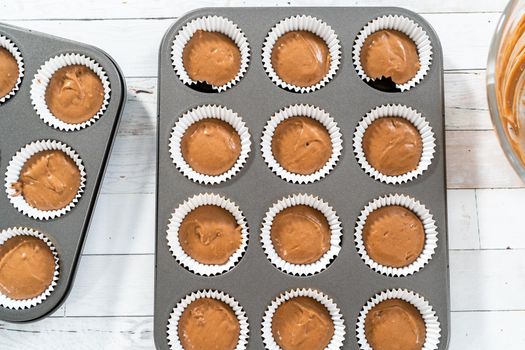 Scooping dough into the foil cupcake liners to bake chocolate raspberry cupcakes.