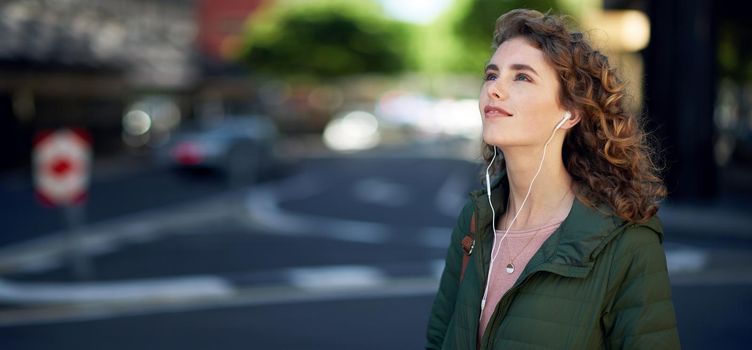 beautiful woman walking in city street listening to music wearing earphones urban lifestyle.