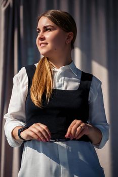 Confident business woman boss standing in modern office, female leader, business owner thinking about future success, planning new opportunities