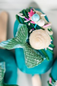 Mermaid cakesicles with drizzled chocolate, chocolate mermaid tails, seashells, and sprinkles.