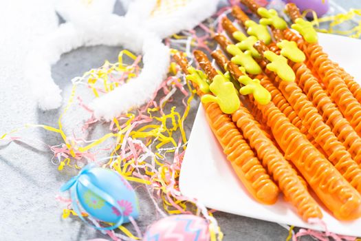 Carrot chocolate-covered pretzels on a white serving plate for the Easter table.
