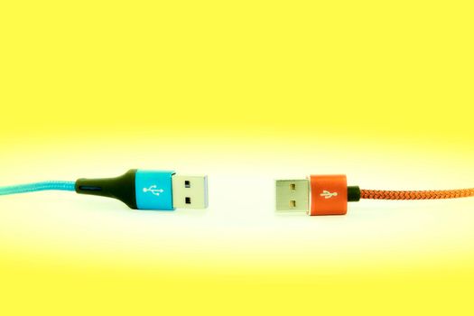 bring together or into contact so that a real or notional link is established. Blue red Universal Serial Bus cables isolated on yellow background.
