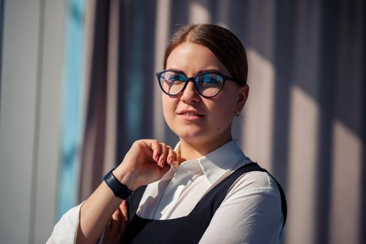 Confident business woman boss standing in modern office wearing glasses, female leader, business owner thinking about future success, planning new opportunities