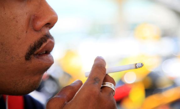 salvador, bahia, brazil - august 12, 2021: Man is seen smoking cigarette on the street in Salvador city.