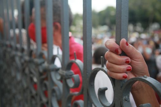 salvador, bahia, brazil - december 8, 2021: devotees hold a church fence during mass in honor of Nossa Senhora da Conceicao da Praia in the city of Salvador.