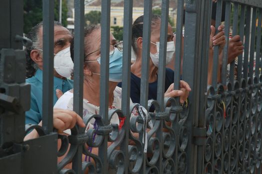 salvador, bahia, brazil - december 8, 2021: devotees hold a church fence during mass in honor of Nossa Senhora da Conceicao da Praia in the city of Salvador.