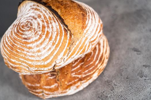 Freshly baked loaf of a wheat sourdough bread with marks from bread proofing basket.
