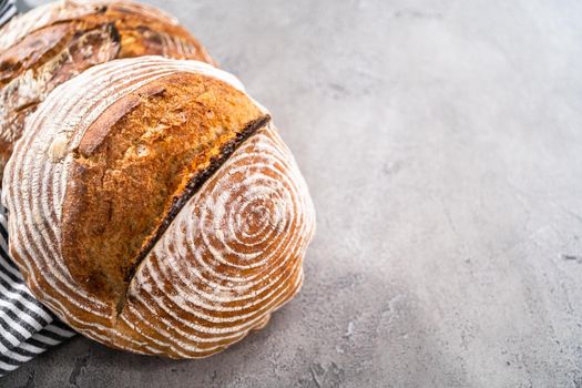 Freshly baked loaf of a wheat sourdough bread with marks from bread proofing basket.