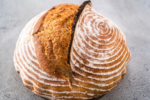 Freshly baked loaf of a wheat sourdough bread with marks from bread proofing basket.