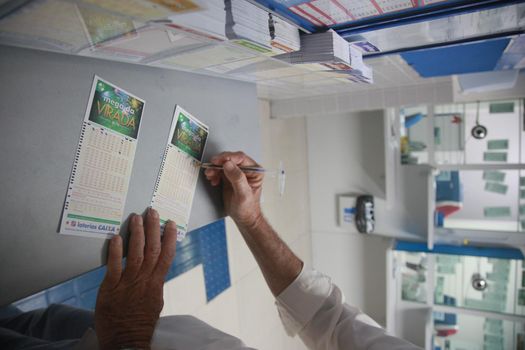 salvador, bahia, brazil - december 21, 2021: bettor filling Mega Sena da Virada bet at a lottery shop in the city of Salvador.