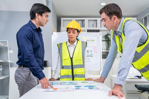 A group of competent engineers and employer discuss plans in the office. Architectural investor, businessman, and engineer discussing blueprints.