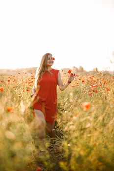 A woman of European appearance with long blonde hair and a red summer dress, she stands in a blooming poppy field