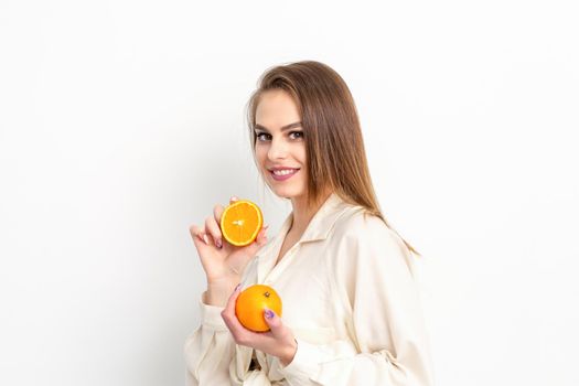 Young Caucasian smiling woman with slices orange over isolated white background