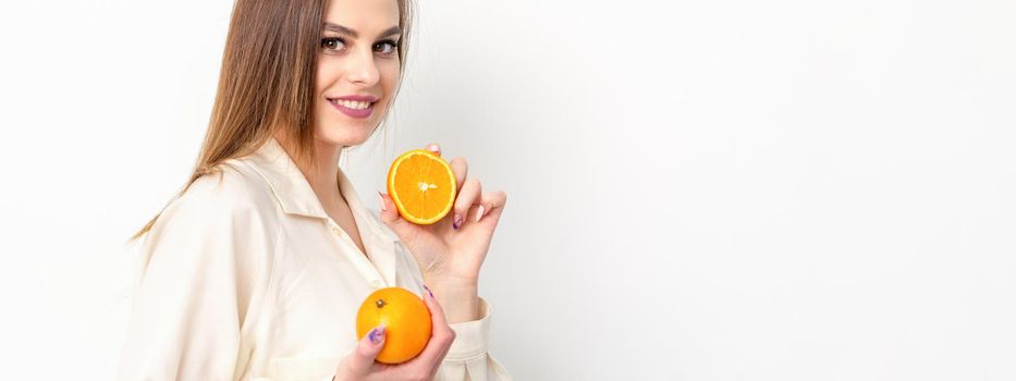 Young Caucasian smiling woman with slices orange over isolated white background