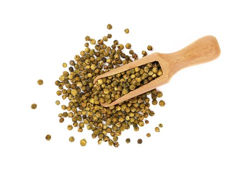 Close up one wooden scoop full of green pepper peppercorns and heap of peppercorns spilled and spread around isolated on white background, elevated top view, directly above