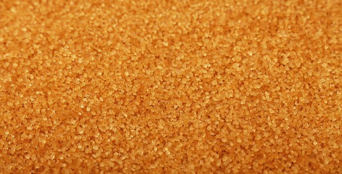 Close up background texture of brown raw cane sugar, high angle view