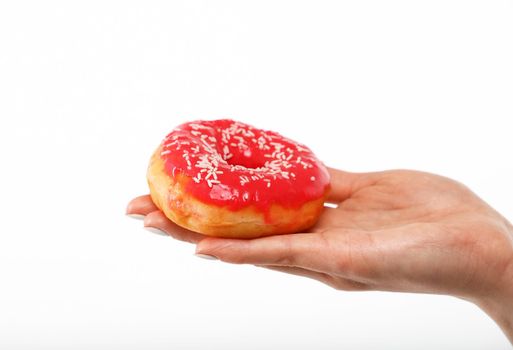 Close up Caucasian woman hand holding one red icing glazed ring doughnut isolated on white background, symbol of unhealthy eating concept, low angle, side view