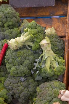 Close up many fresh green broccoli cabbages at retail display of farmer market, high angle view