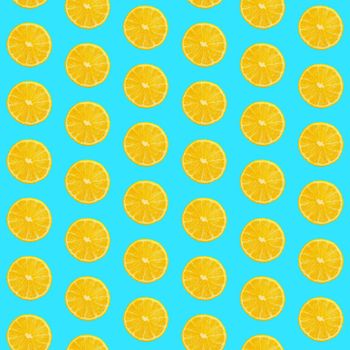 Seamless pattern of fresh ripe orange round cut wedges on pastel blue background