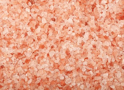 Close up background texture of large or medium crystals pink Himalayan salt, elevated top view, directly above
