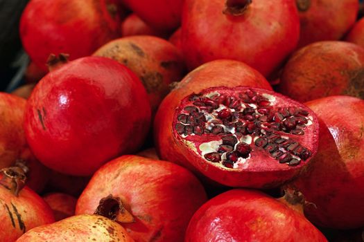 Close up fresh red ripe pomegranates at retail market stall display, high angle view