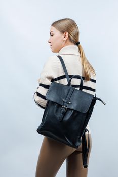 Black backpack on the shoulder of a woman, Women's backpack, gray women's backpack. Women's bag isolated on white background. The bag is isolated on a white background.