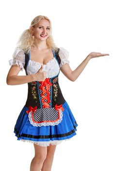 Beautiful young blond girl in dirndl drinks out of oktoberfest beer stein. Isolated on white background. pointing finger and smiling. copyspace desing concept