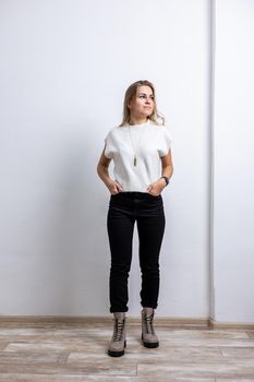 A slender woman in black leather boots, black trousers. Collection of shoes for women