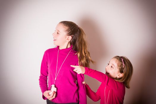 Couple of Little Girls Taking Picture Using Toy Photo Camera on white background. High quality photo