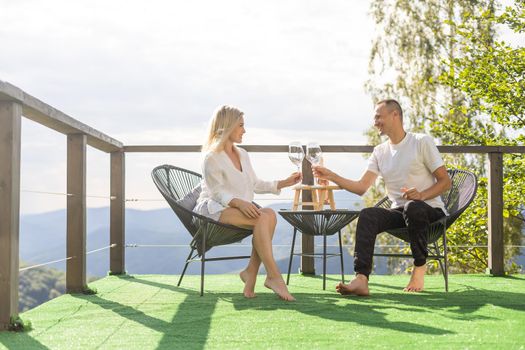 Happy couple sitting in a cozy home with a mountain view