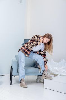Stylish pretty young woman in fashionable clothes with blue jeans and fashionable shoes. Beautiful female legs in leather boots