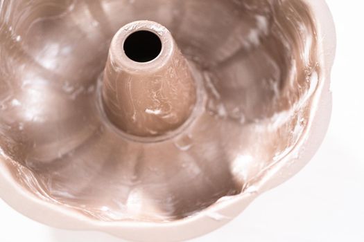 Greased metal bundt cake pan to bake chocolate bundt cake with chocolate frosting.