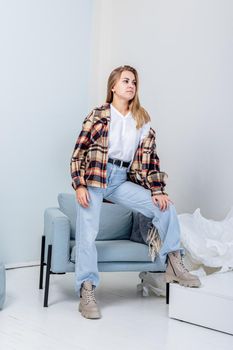 Stylish pretty young woman in fashionable clothes with blue jeans and fashionable shoes. Beautiful female legs in leather boots