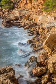 Cala Salada and Saladeta in san Antonio Abad at Balearic Islands Spain. Long exposure, Typical house for fishing boats and rocks.