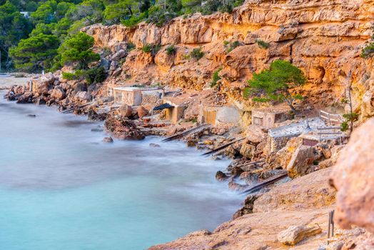 Cala Salada and Saladeta in san Antonio Abad at Balearic Islands Spain. Typical house for fishing boats and rocks.
