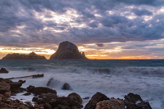 Small wooden pier in Cala d'Hort bay and view of Es Vedra island, Ibiza island, Spain