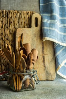 Glass jar with variety of wooden spoons on kitchen table