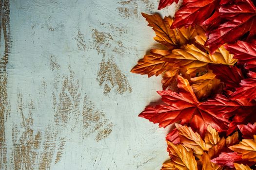 Autumnal flat lay with leaves and pumpkins on wooden background