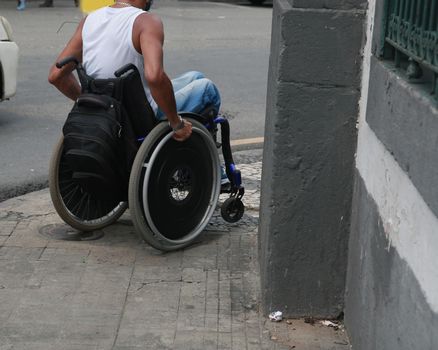 salvador, bahia, brazil - december 2, 2021: wheelchair user in a street in the center of the city of Salvador.