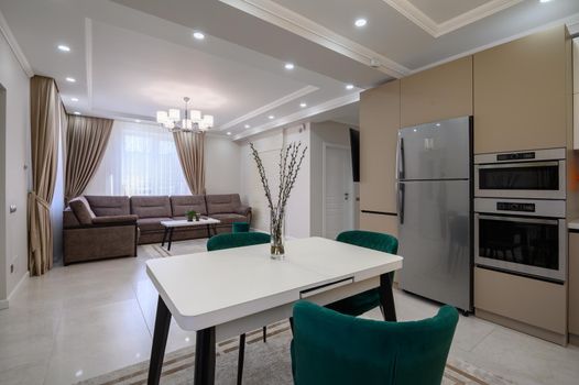 Modern classic white and beige luxurious kitchen with dining room in studio apartment interior